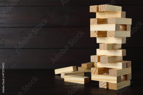 Jenga tower and wooden blocks on table  space for text
