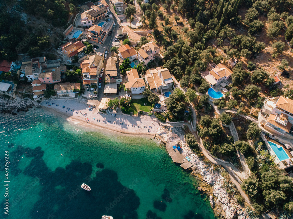 Beautiful beach with turquoise waters near authentic villas. Corfu, Greece. Top-down view.