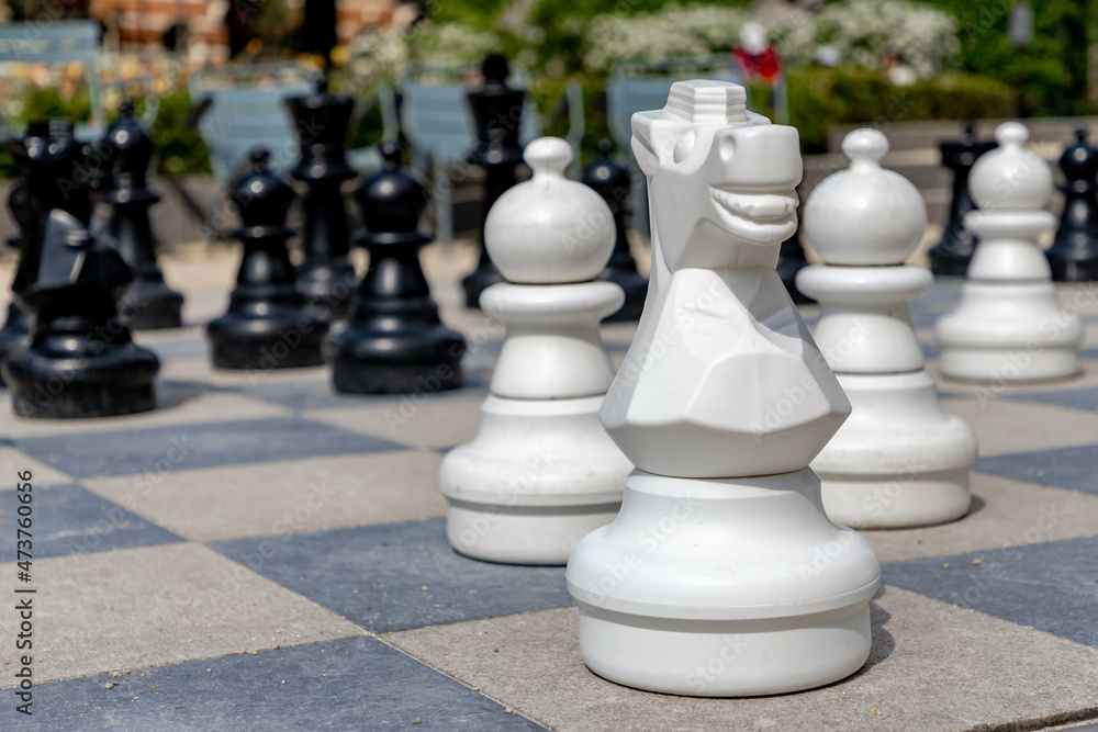 Outdoor oversized chess on the ground in public area zone, Selective focus of big pieces of street chess in the park, Hobby, Leisure and activities.
