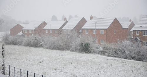 Snow falling on a cold winter day in England in a typical village photo