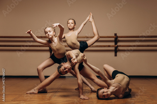 Black and white image of a group of modern little ballerinas standing in a modern dance pose. Copy space