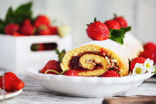Billede på lærred Homemade strawberry shortcake cake roll or Roulade with a berry jam filling and powdered sugar with mint leaves