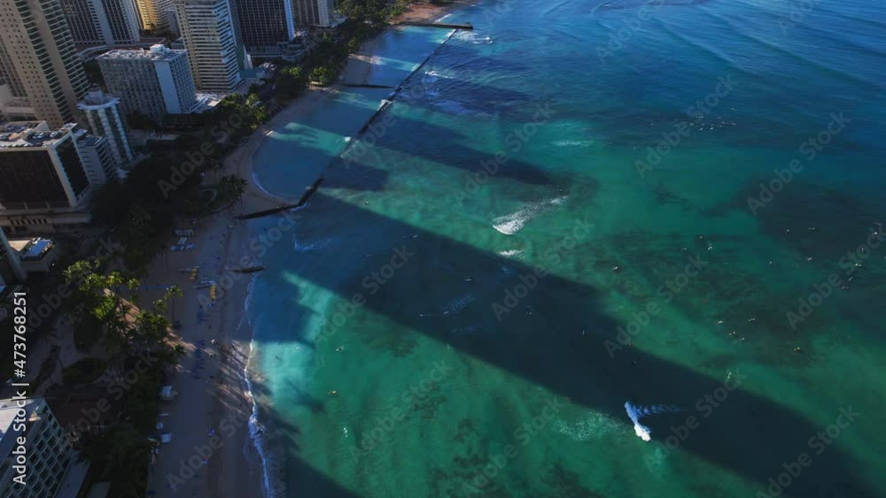 Aerial view of Waikiki beach with green water and resorts - tilt up to Diamond Head. Aerial view of Waikiki beach with green water and resorts - tilt up to Diamond Head.