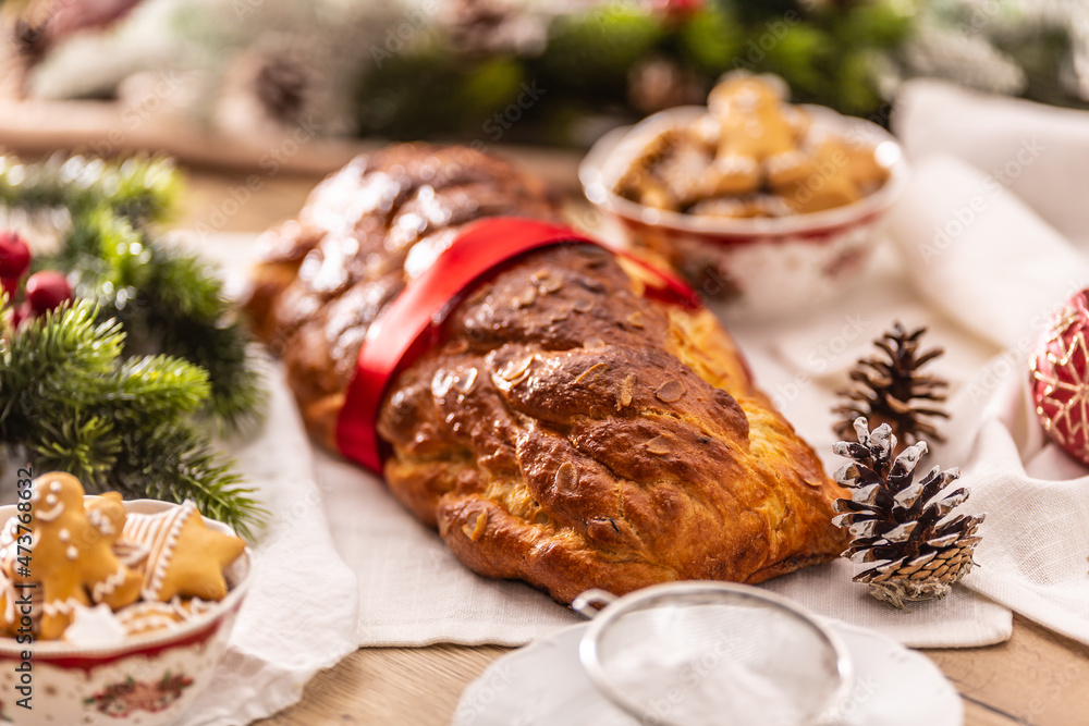 Traditional Czech Christmas cake Vanocka on a festive table in front of a Christmas tree Traditional Czech Christmas cake Vanocka on a festive table in front of a Christmas tree