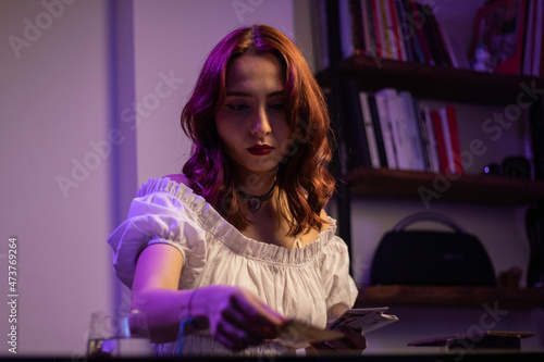 Beautiful fortune teller woman showing tarot cards in her hand.