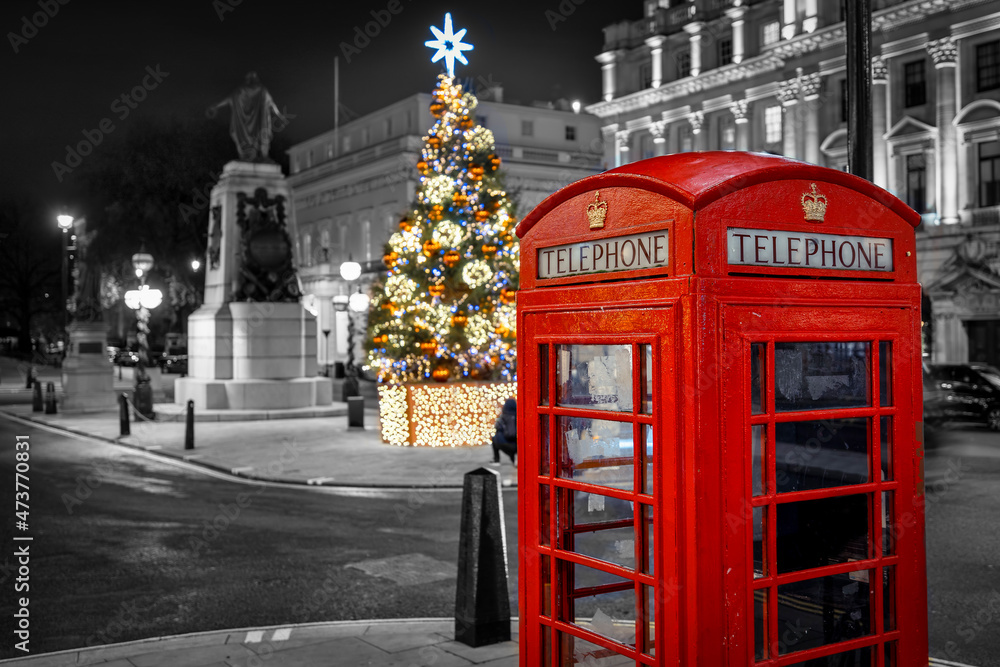Christmas in London with a red telephone booth in front of an illuminated Christmas Tree in Central London, UK, during night time Christmas in London with a red telephone booth in front of an illuminated Christmas Tree in Central London, UK, during night time