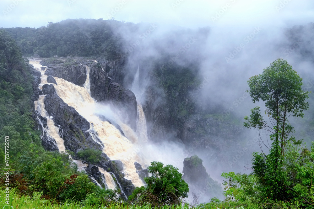 Waterfall in the fog. The Barron Falls (Aboriginal: Din Din) is a steeply tierred cascade waterfall on the Barron River in Cairns, Queensland, Australia.