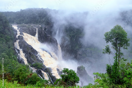 Waterfall in the fog. The Barron Falls (Aboriginal: Din Din) is a steeply tierred cascade waterfall on the Barron River in Cairns, Queensland, Australia. photo