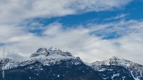 panorama of high mountains covered by snow cloudy blue sky british columbia canada