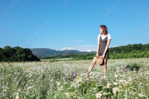 beautiful woman travels walking a field of daisies © dmitriisimakov