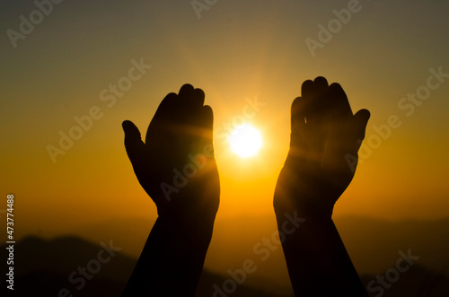 hands holding the sun at dawn. Freedom and spirituality concept.