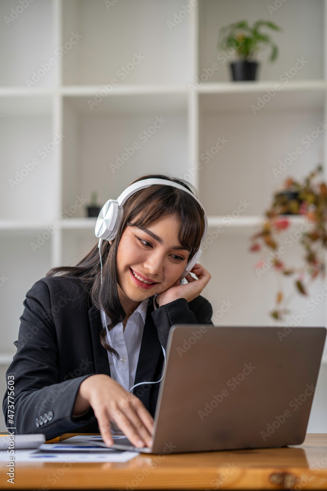 Portrait of a business woman happily wearing music headphones while working to relax after a hard day's work. Portrait of a business woman happily wearing music headphones while working to relax after a hard day's work.