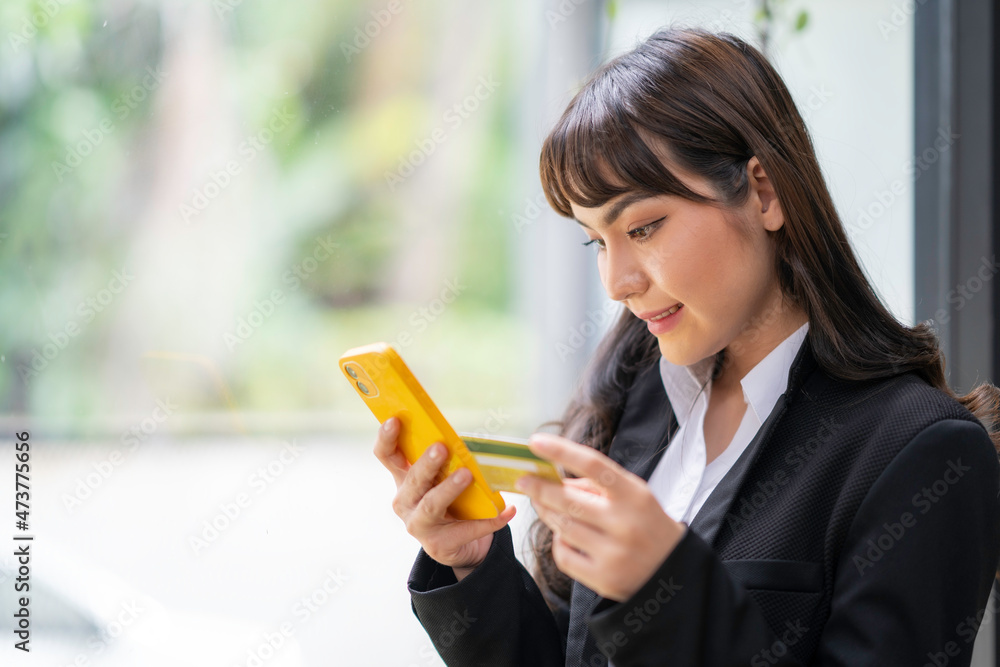 Businesswoman holding credit card while using laptop computer to buy or pay online, online shopping. Businesswoman holding credit card while using laptop computer to buy or pay online, online shopping.