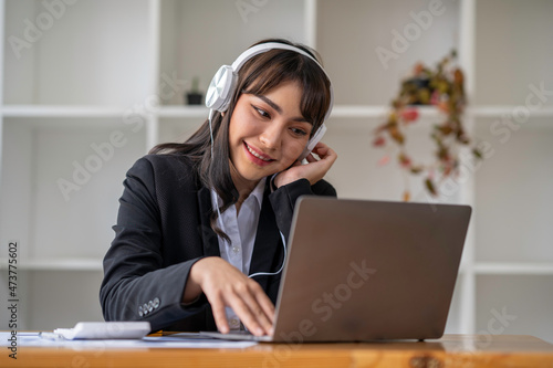 Portrait of a business woman happily wearing music headphones while working to relax after a hard day's work.