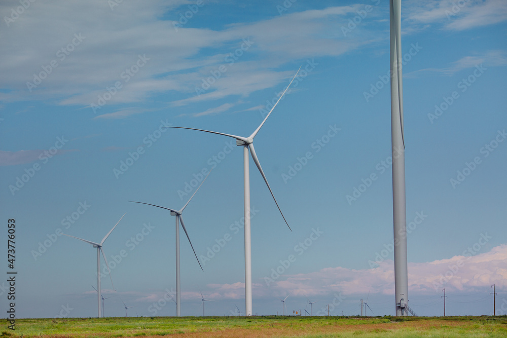Fototapeta premium Wind turbines renewable energy source in the fields against the background of clouds