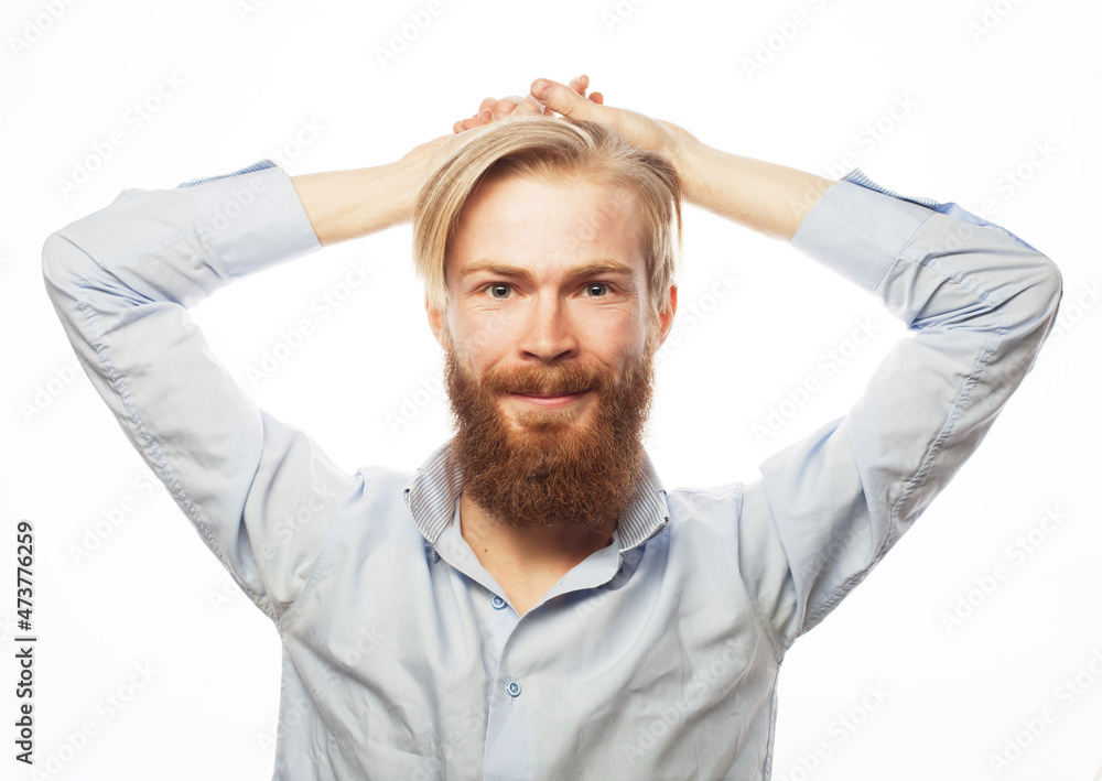 Young bearded guy with fashionable hairstyle and beard crossed his arms behind his head Young bearded guy with fashionable hairstyle and beard crossed his arms behind his head