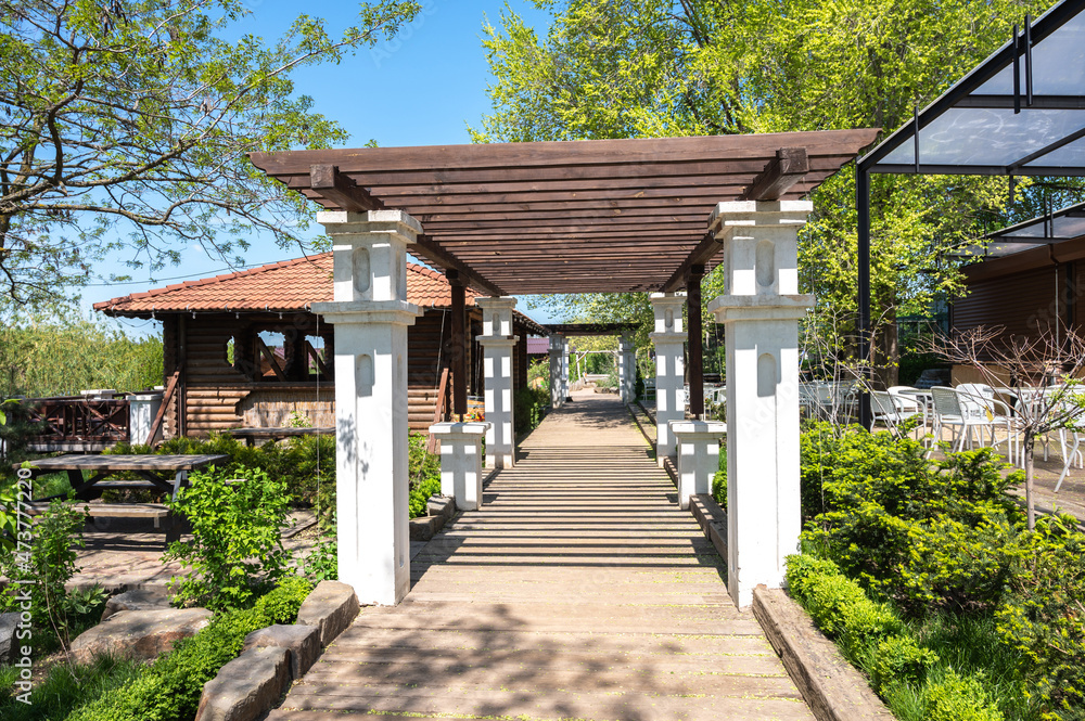 Spring park with green foliage and wooden gazebos. Spring park with green foliage and wooden gazebos.