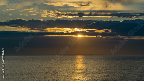 Beautiful sea landscape with sunset on the horizon. Sochi, Black Sea coast of south of Russia. Scenic sky with clouds over the golden water of Black sea. Luxury clouds and natural sky background © MarinoDenisenko