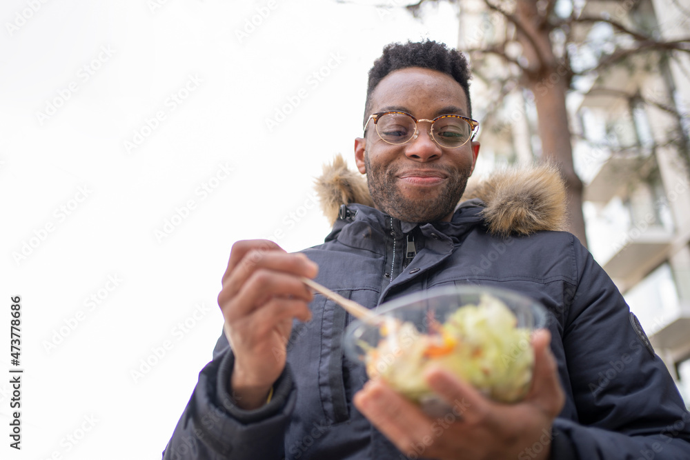 Smiling man with eyeglasses having salad during winter Smiling man with eyeglasses having salad during winter