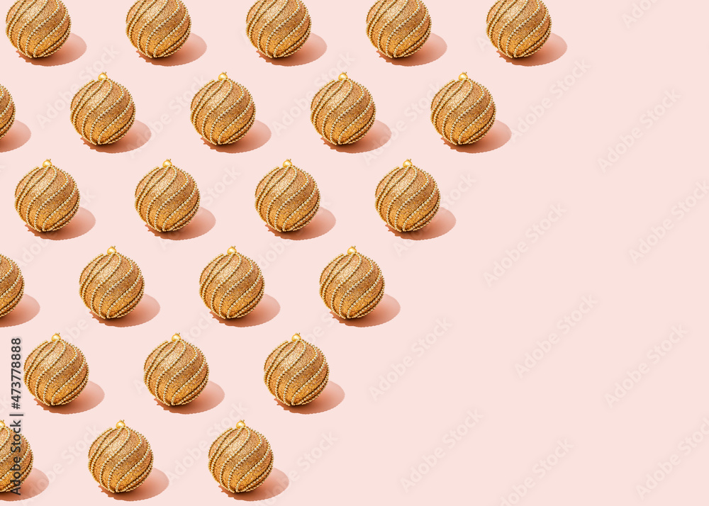 Pattern of golden Christmas ornaments flat laid against pink background Pattern of golden Christmas ornaments flat laid against pink background