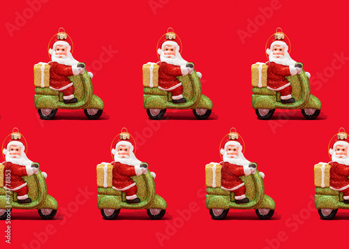 Pattern of Santa Claus Christmas ornaments against vibrant red background photo