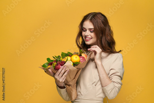 portrait of a woman fun posing fruit bouquet vitamins colorful background