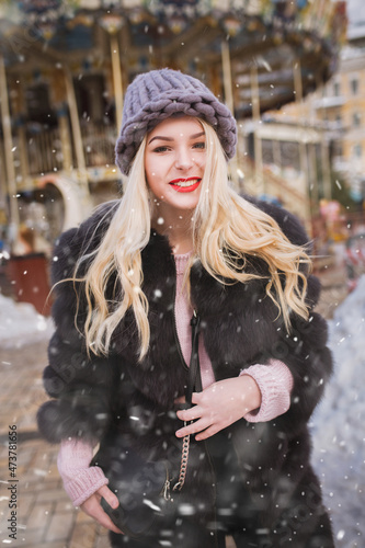 Cheerful lady enjoying holiday fair in snowfall