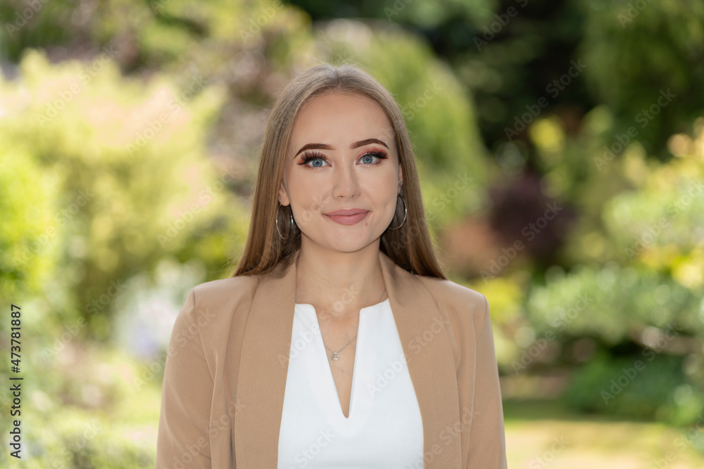 Portrait of smart, blonde, smiling woman in garden with professional, business image. Portrait of smart, blonde, smiling woman in garden with professional, business image.