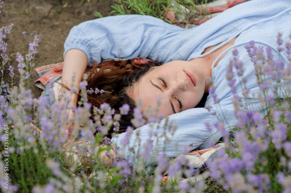 Young woman lying in lavender field on summer day Young woman lying in lavender field on summer day