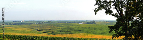 Wide panorama view of farm fields, reaching off into the distance. Rolling hills and wide open spaces.