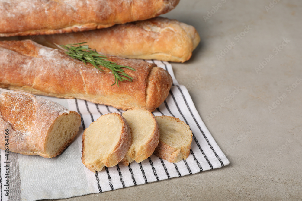 Fresh crispy baguettes on grey table, closeup. Space for text