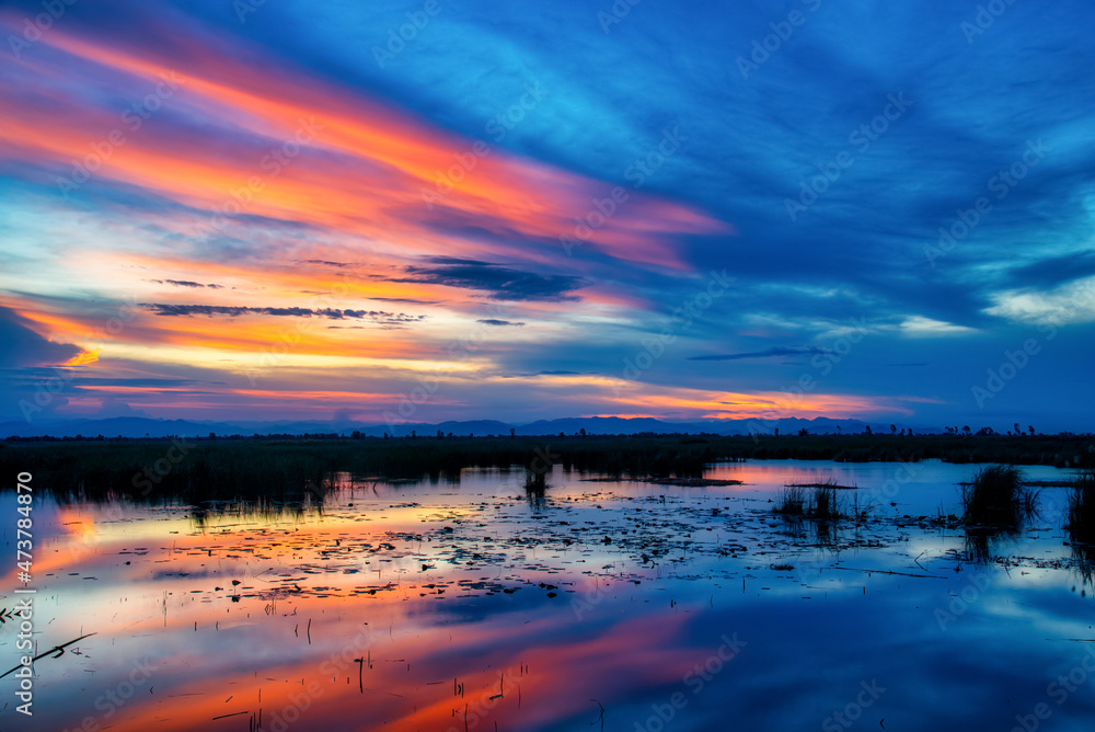 Dramatic sunset sky with clouds over mountian and lagoon