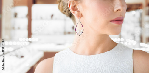 luxury and people concept - beautiful woman in evening dress wearing pearl earrings over jewelry store background