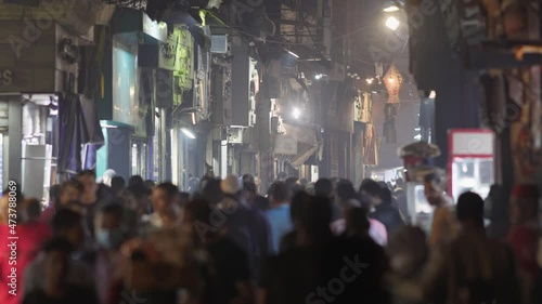 Unrecognizable people walk the busy El Moez street in Old Cairo, Egypt. Al-Muizz li-Din Allah al-Fatimi Street - major north-to-south street in the walled city of historic Cairo photo