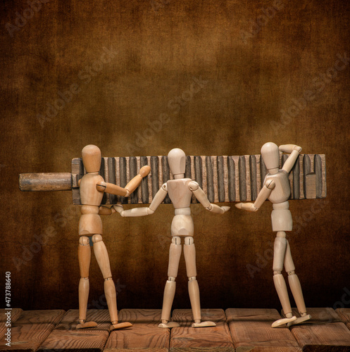 Gestalt wooden men play with a washboard on a wooden table and on an artistic background.