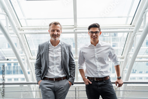 Smiling businessman standing by colleague in office photo