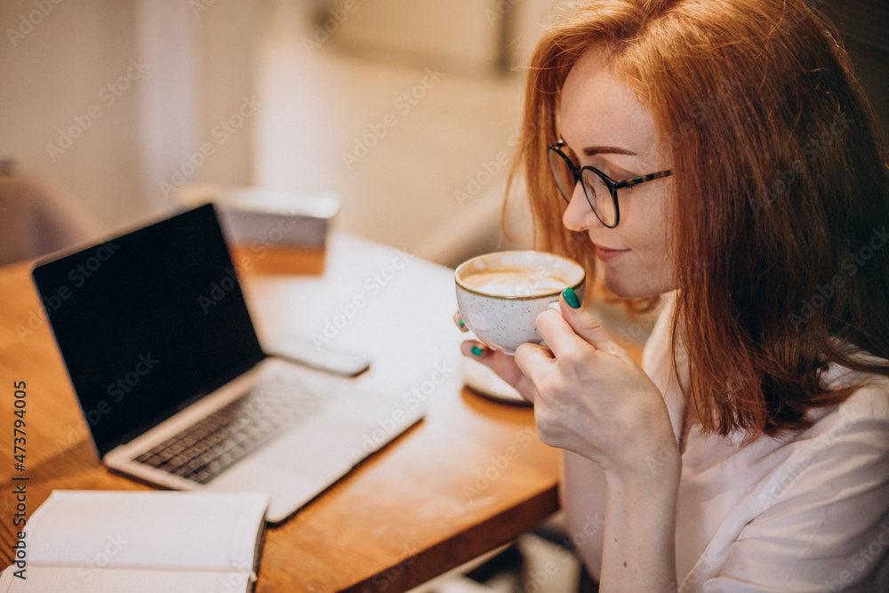 Business woman working on computer in cafe and drinking coffee Business woman working on computer in cafe and drinking coffee
