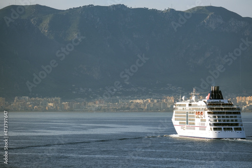 Silhouette of Hapag luxury Europa 2 cruiseship cruise ship liner yacht at sea during twilight sunrise horizon cruising towards port of Palermo, Sicily Italy during Mediterranean cruising photo