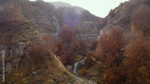 Aerial 4K footage of Morricana Waterfalls in Monti della Laga, Abruzzo, Italy, in the full autumn season with red and orange trees photo