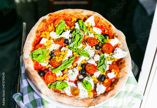 Travel Italy, Part of Italian culture - healthy mediterranean food. Rome street restaurants and pizzeria. Fresh pizza with mozarella ,basilic and tomatos photo