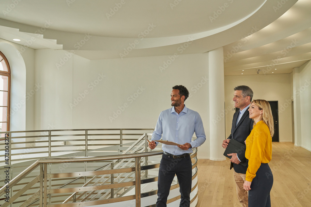 © Westend61 - Male real estate agent showing unfurnished house to business couple