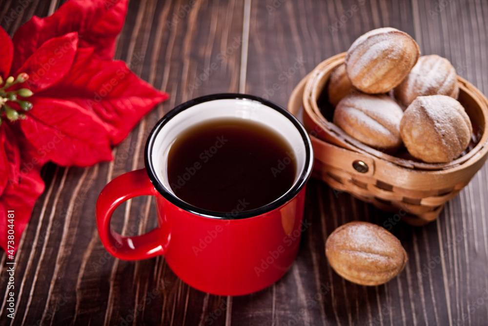 Mug of tea with homemade fresh cookies in a shape of nuts with condensed milk on the wooden table