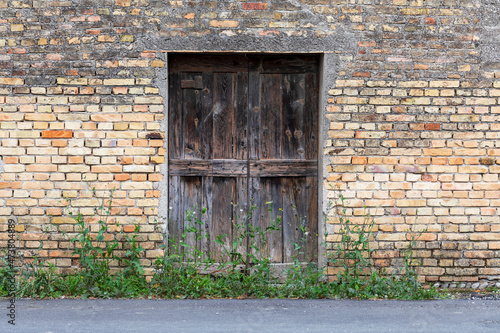 Veccia porta chiusa in legno di casa su facciata di edificio in mattoni. photo