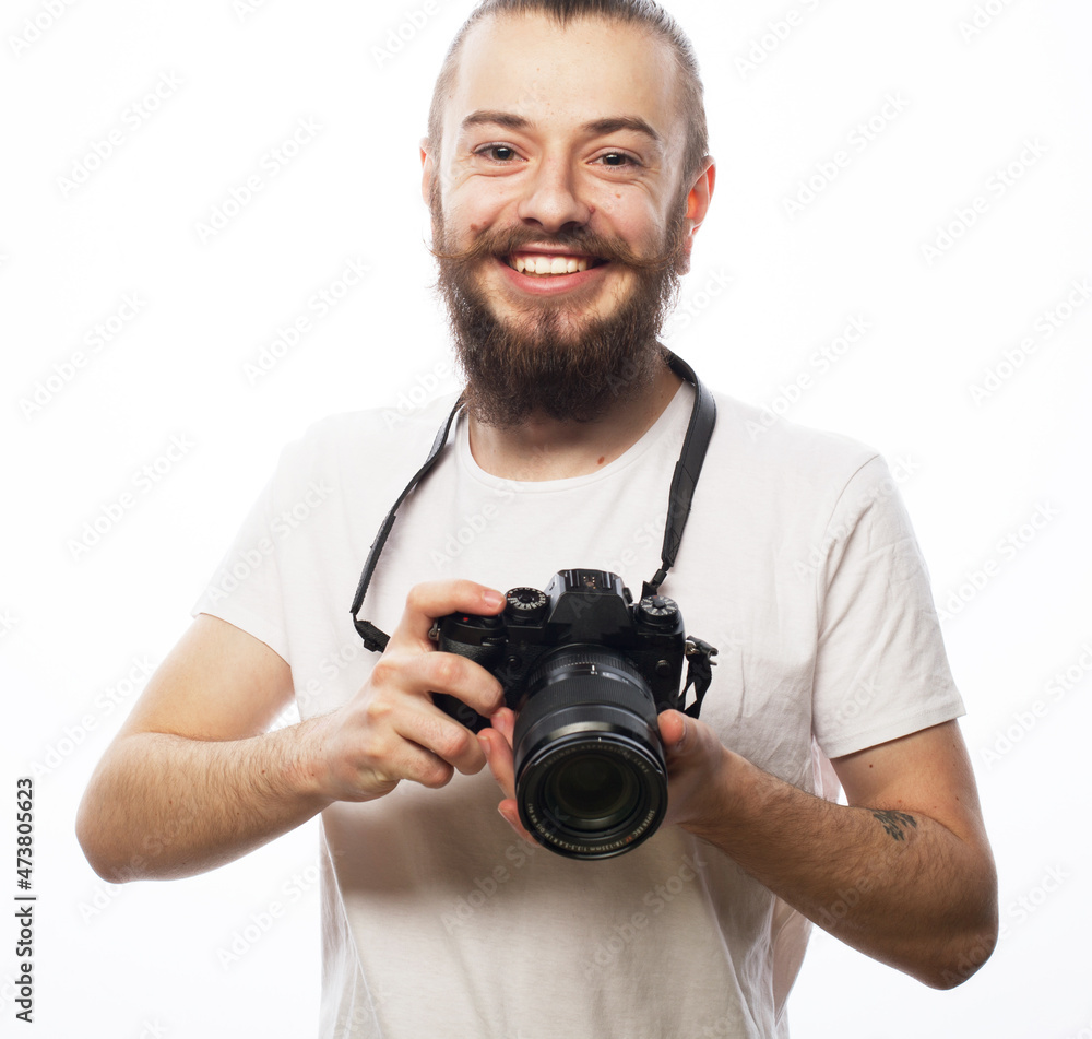 young bearded man wearing white t-shirt with a digital camera young bearded man wearing white t-shirt with a digital camera