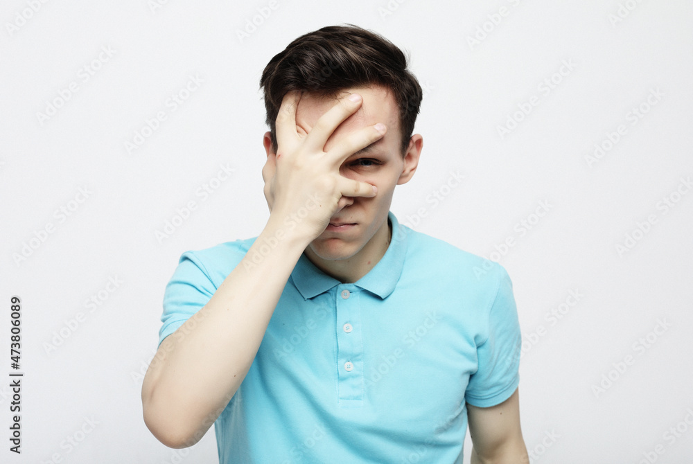 Stressed upset man suffering from a strong migraine isolated over white gray background Stressed upset man suffering from a strong migraine isolated over white gray background