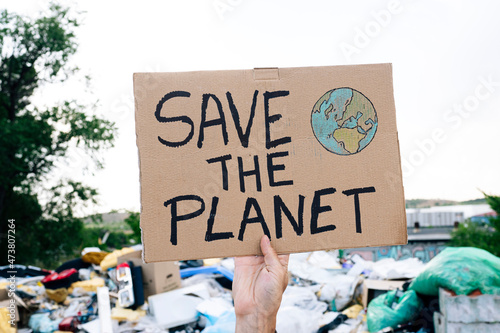 Man holding save the planet text on cardboard photo