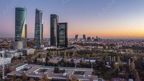 Backwards reveal of modern high rise buildings in business district. Aerial hyperlapse footage of at dusk. Madrid, Spain photo
