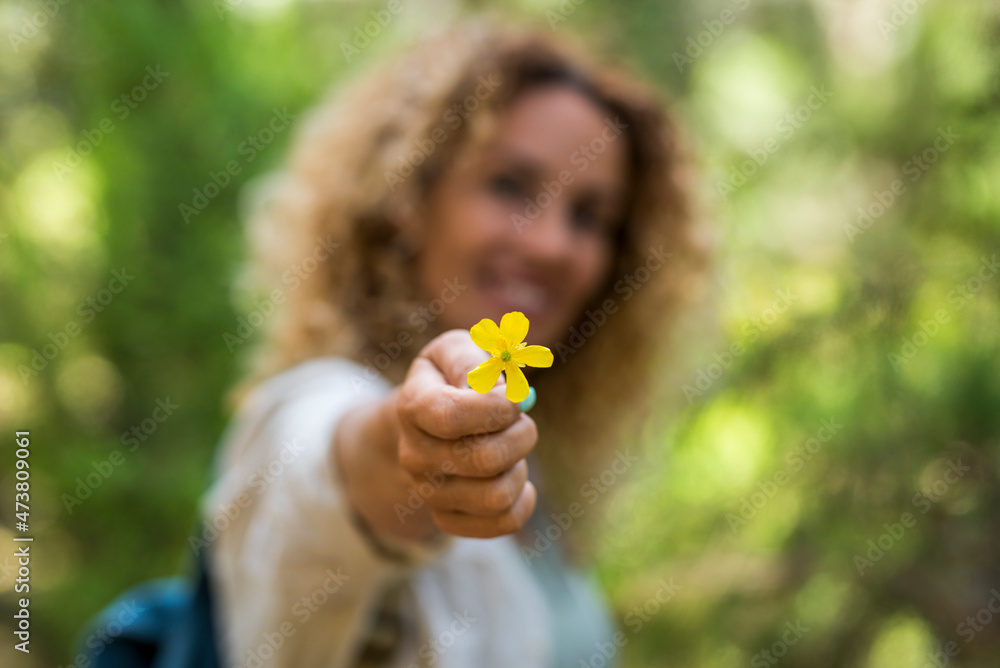 Woman holding yellow wildflower during vacation Woman holding yellow wildflower during vacation