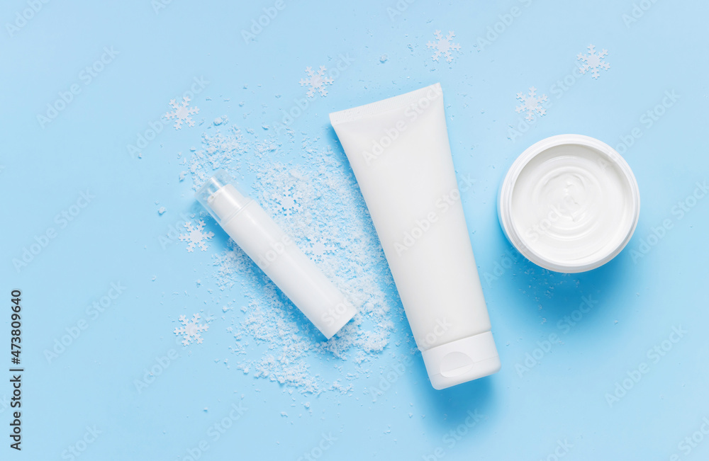 Top view bottles with face cream, mask and under eye serum on the snow, winter skin care Top view bottles with face cream, mask and under eye serum on the snow, winter skin care