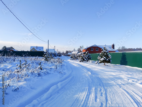 Country rough road on snow in winter season. Russian rural outdoor landscape.